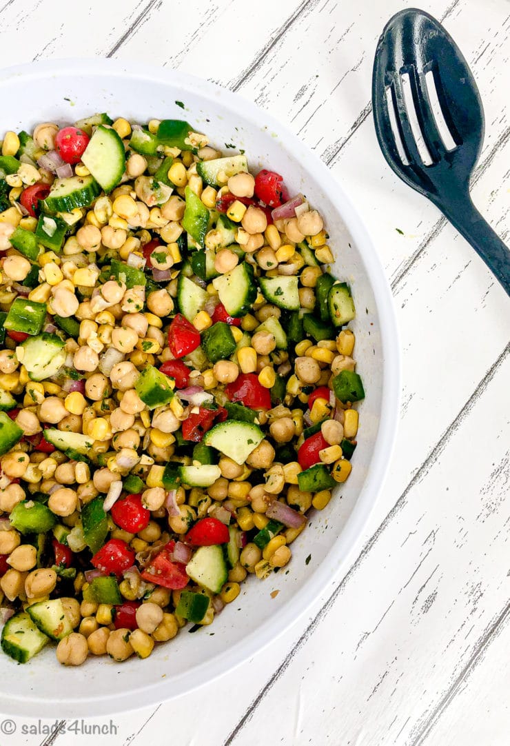 Cilantro lime chickpea salad in a white bowl on white wood countertop