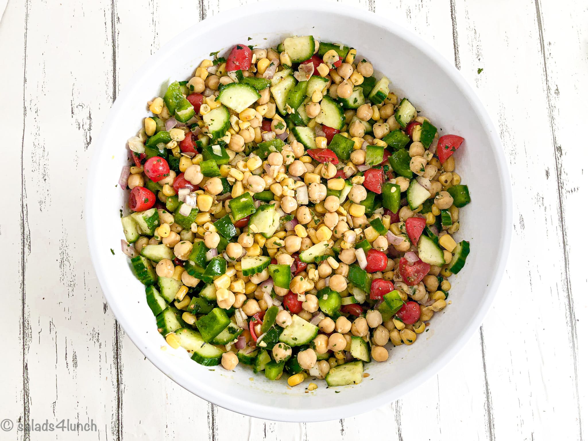 Cilantro lime chickpea salad in a white bowl on white wood countertop
